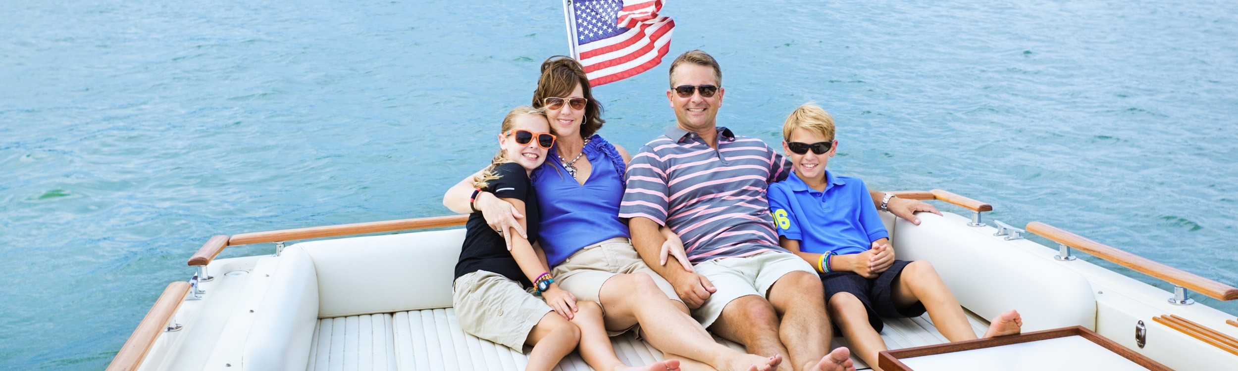 family of 4 sitting together on a boat